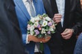 Groom in blue suit is holding beautiful elegant wedding bouquet in hands. Eustoma, freesia and pink roses flowers Royalty Free Stock Photo