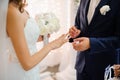 Groom puts on a gold wedding ring on the finger of a beautiful bride Royalty Free Stock Photo