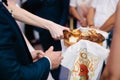 The groom breaks off a piece of the wedding loaf