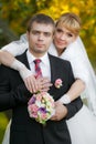 Groom and the bride in autumn park walk near trees with yellow leaves Royalty Free Stock Photo