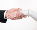 Groom and bride hands hold together on white