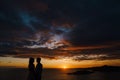 Groom and bride hold hands at sunset against the background of the sea Royalty Free Stock Photo