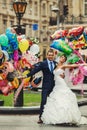 Groom and bride holding ballons on the background city