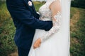 Groom and bride are hugging. Happy wedding couple photo. Romantic photoshoot. White dress with long sleeves. Lace veil Royalty Free Stock Photo