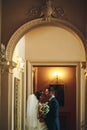 Groom and bride is kissing on the background hall Royalty Free Stock Photo