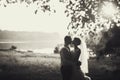 Groom and bride is kissing on the background lake and forest Royalty Free Stock Photo