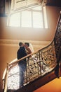 Groom and bride is kissing on the background stairs Royalty Free Stock Photo