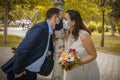 Groom and bride kissing each other in protective medical masks on face in Royalty Free Stock Photo