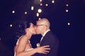 Groom and bride kissing with fireworks in background