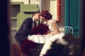 Groom and bride kissing in a openair restaurant Royalty Free Stock Photo