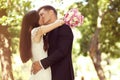 Groom and bride kissing in the park