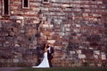 Groom and bride near a brick wall Royalty Free Stock Photo