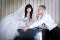 Groom and bride near a grand piano