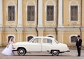 Groom and bride near white vintage car Royalty Free Stock Photo