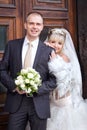 Groom and bride near a wooden door