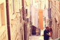 Groom and bride outdoors on a narrow street on their wedding day Royalty Free Stock Photo