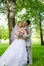 The groom and the bride in park near a tree Royalty Free Stock Photo