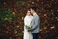 Groom and bride posing at autumn forest, among leaves. Royalty Free Stock Photo