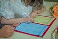 Groom and bride register marriage. Woman puts his signature on wedding . A woman& x27;s hand signs and registers his marriage Royalty Free Stock Photo