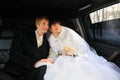 Groom and bride sitting inside limousine Royalty Free Stock Photo