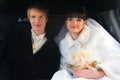 Groom and bride sitting inside limousine Royalty Free Stock Photo