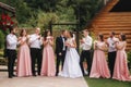 Groom and bride stand with groomsman and bridesmaid outside. Newlyweds kissing and friend clap. Wedding day Royalty Free Stock Photo