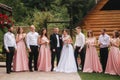 Groom and bride stand with groomsman and bridesmaid outside. Newlyweds kissing and friend clap. Wedding day Royalty Free Stock Photo