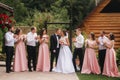Groom and bride stand with groomsman and bridesmaid outside. Newlyweds kissing and friend clap. Wedding day Royalty Free Stock Photo