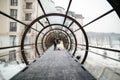 Groom and bride walking in glasses tunnel. Outside is winter