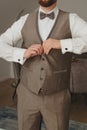 Groom buttons up the front of the waistcoat