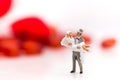 The groom carries the bride in a white wedding dress on a wedding day, with a red heart as a back ground Royalty Free Stock Photo