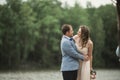 Groom carrying bride near lake and forest Royalty Free Stock Photo