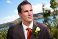 Groom and corsage with blue water behind Royalty Free Stock Photo