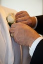 Groom corsage placement in wedding preparation