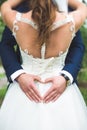Groom creating heart shape with his hands on the back of the bride.Couple in love. Close up of hands. Young couple has done heart Royalty Free Stock Photo