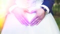 Groom creating heart shape with his hands on the back of the bride.Couple in love. Close up of hands. Young couple has done heart Royalty Free Stock Photo