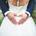 Groom creating heart shape with his hands on the back of the bride.Couple in love. Close up of hands. Young couple has done heart Royalty Free Stock Photo