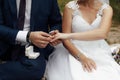 The groom in a dark blue suit puts a gold engagement ring on the finger of his bride Royalty Free Stock Photo