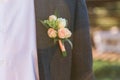 Groom in dark gray vintage suit with a gently pink roses boutonniere Royalty Free Stock Photo