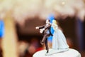 Groom doll and statue is running away but bride can catch him finally. the funny wedding story doll on the top of cake Royalty Free Stock Photo