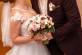 The groom embraces the bride, close,Bridal bouquet