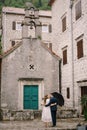 Groom embraces bride near the green door of the ancient church. Back view Royalty Free Stock Photo