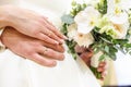 Groom embraces the bride with wedding white rose bouquet. rings on the hands of newly-married couple Royalty Free Stock Photo