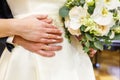 Groom embraces the bride with wedding white rose bouquet. rings on the hands of newly-married couple Royalty Free Stock Photo