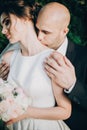 Groom gently kissing gorgeous bride on neck in sunset light. Portraits of beautiful tender wedding couple embracing in warm Royalty Free Stock Photo