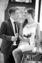 Groom with a glass of champagne and the bride with a bouquet from roses Royalty Free Stock Photo