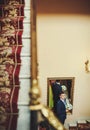 Groom is going up stairs and holding bouquet Royalty Free Stock Photo