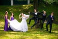 Groom and groomsmen jump behind pretty ladies