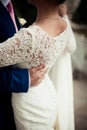 Groom hand on brides dress