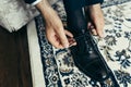 Groom hands are tying the fashionable shiny black shoes. Close-up view.